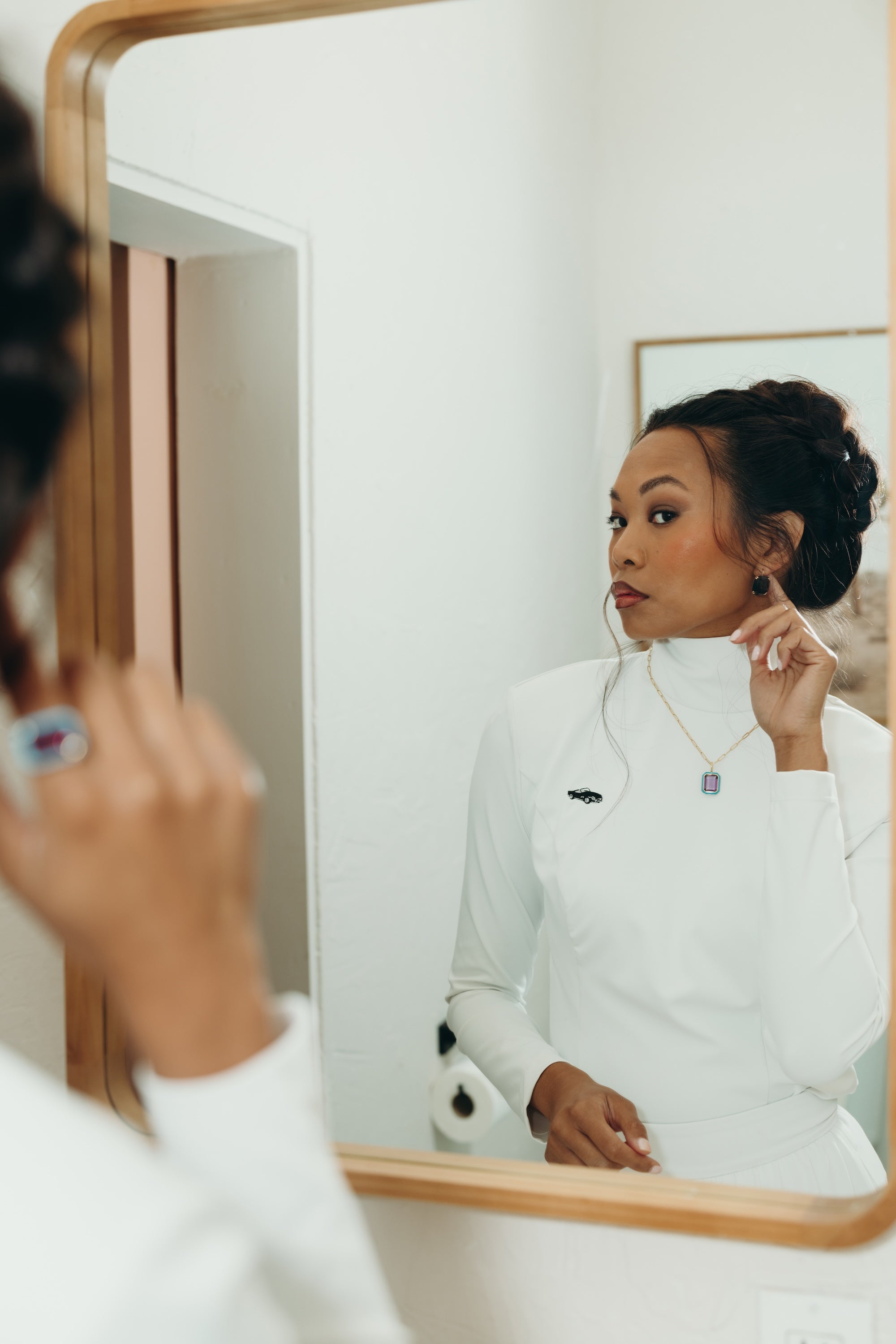 Woman in a wearing Enza Marie Top and Pant admiring her outfit and jewelry in a mirror.