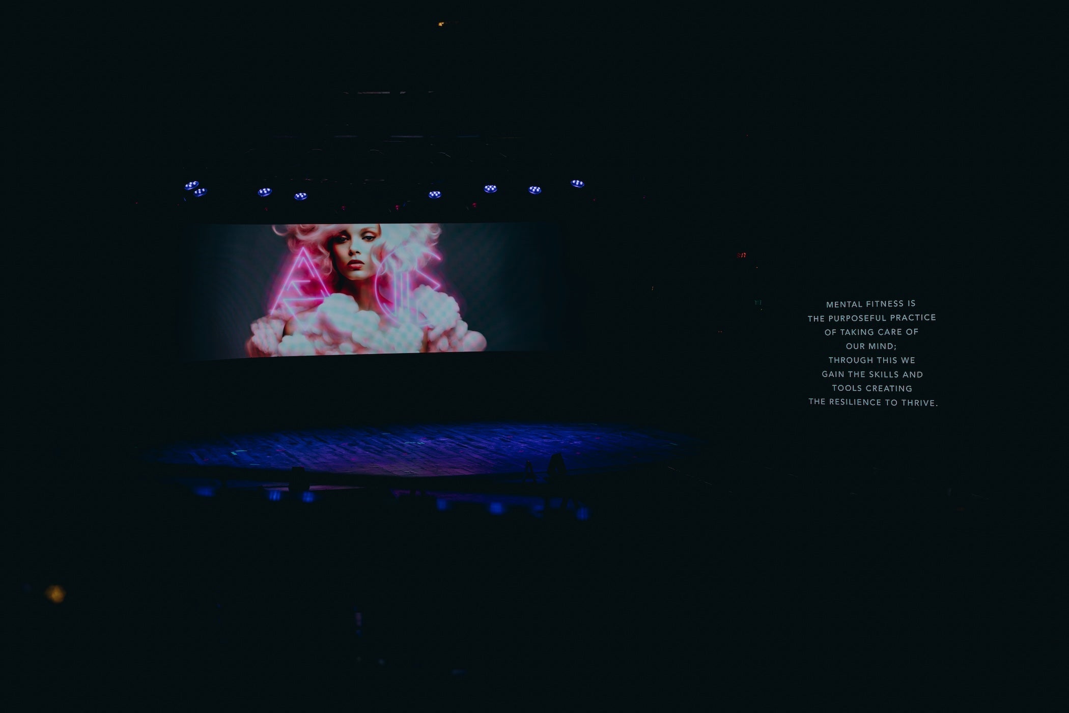 Stage with a vibrant visual presentation promoting mental wellness and resilience during a fashion show.