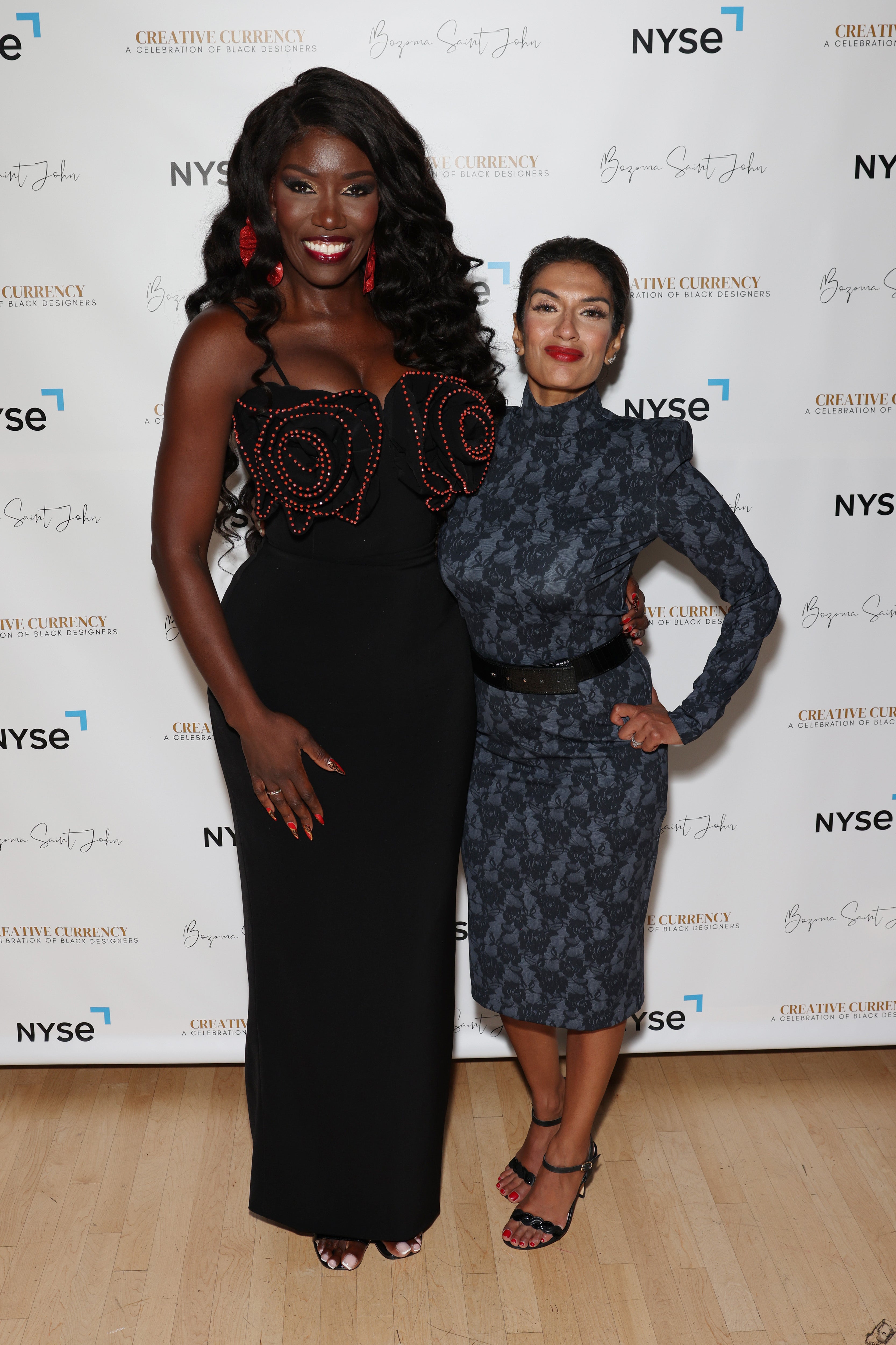 Two elegantly dressed women pose together at a creative event, showcasing Black Widow and confidence.