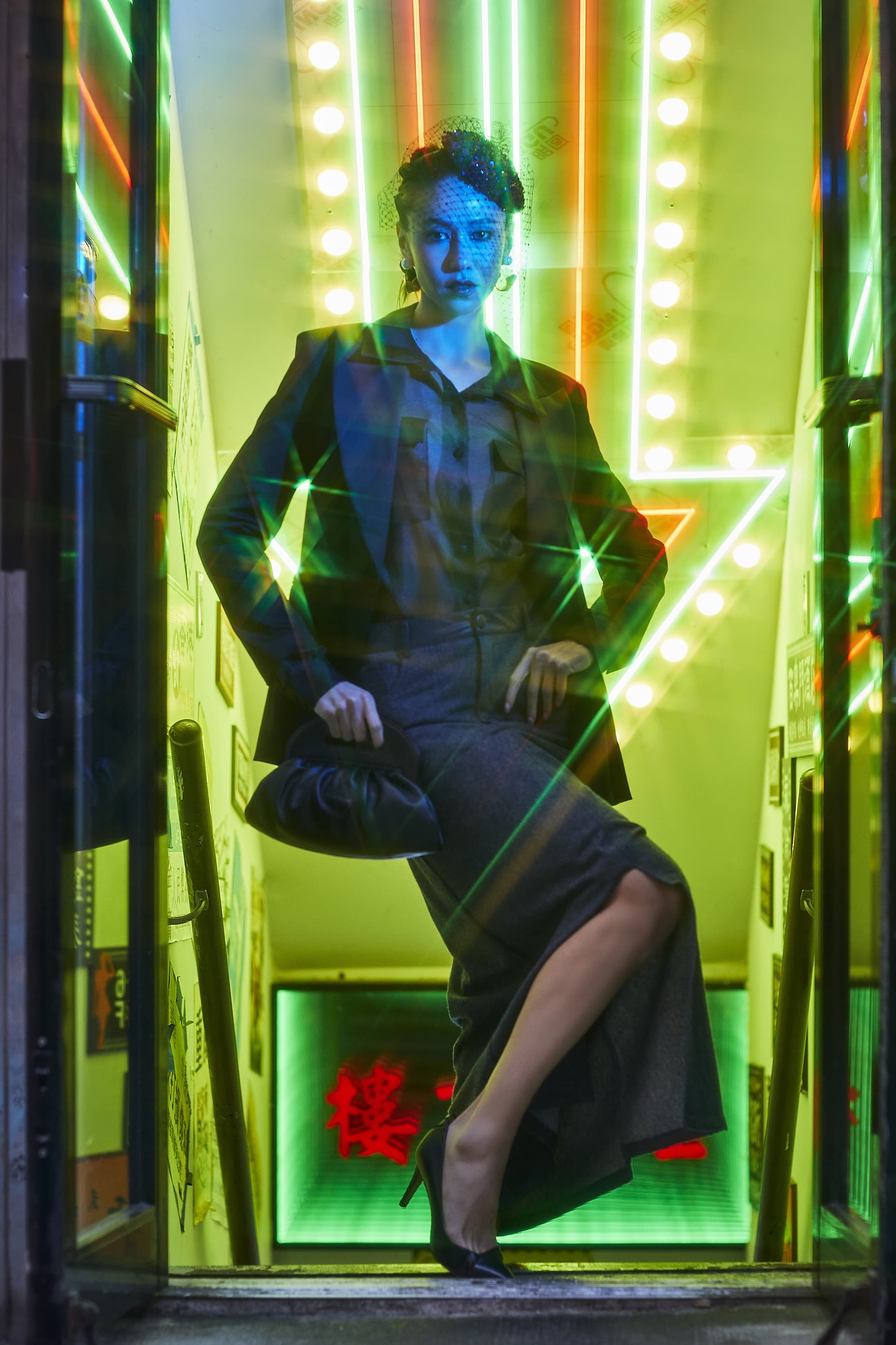 Stylish model posing in vibrant neon-lit doorway, showcasing Starry Night blazer and dramatic lighting effects.