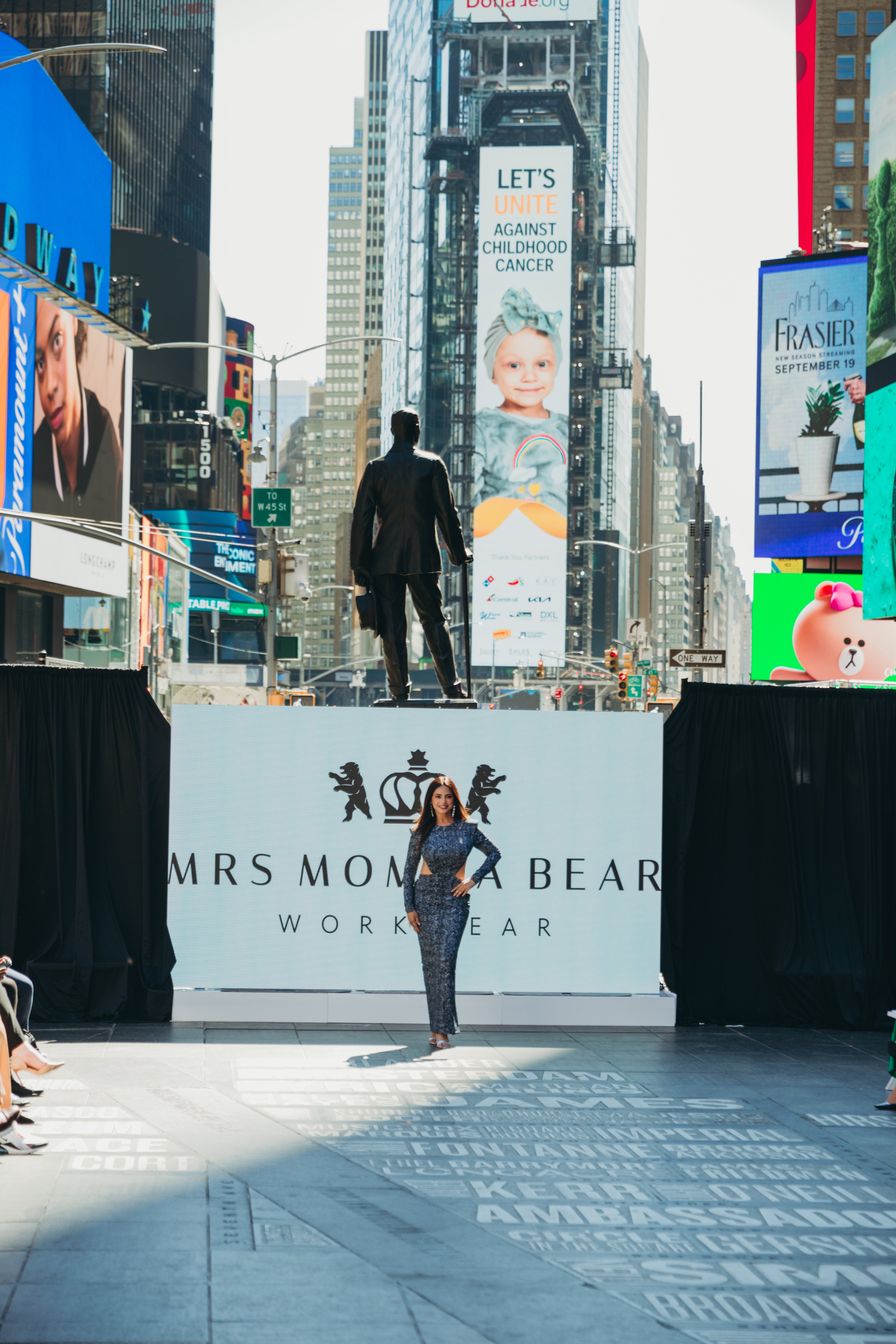 Fashion model poses at Times Square event for Mrs Momma Dear workwear, showcasing Supernova