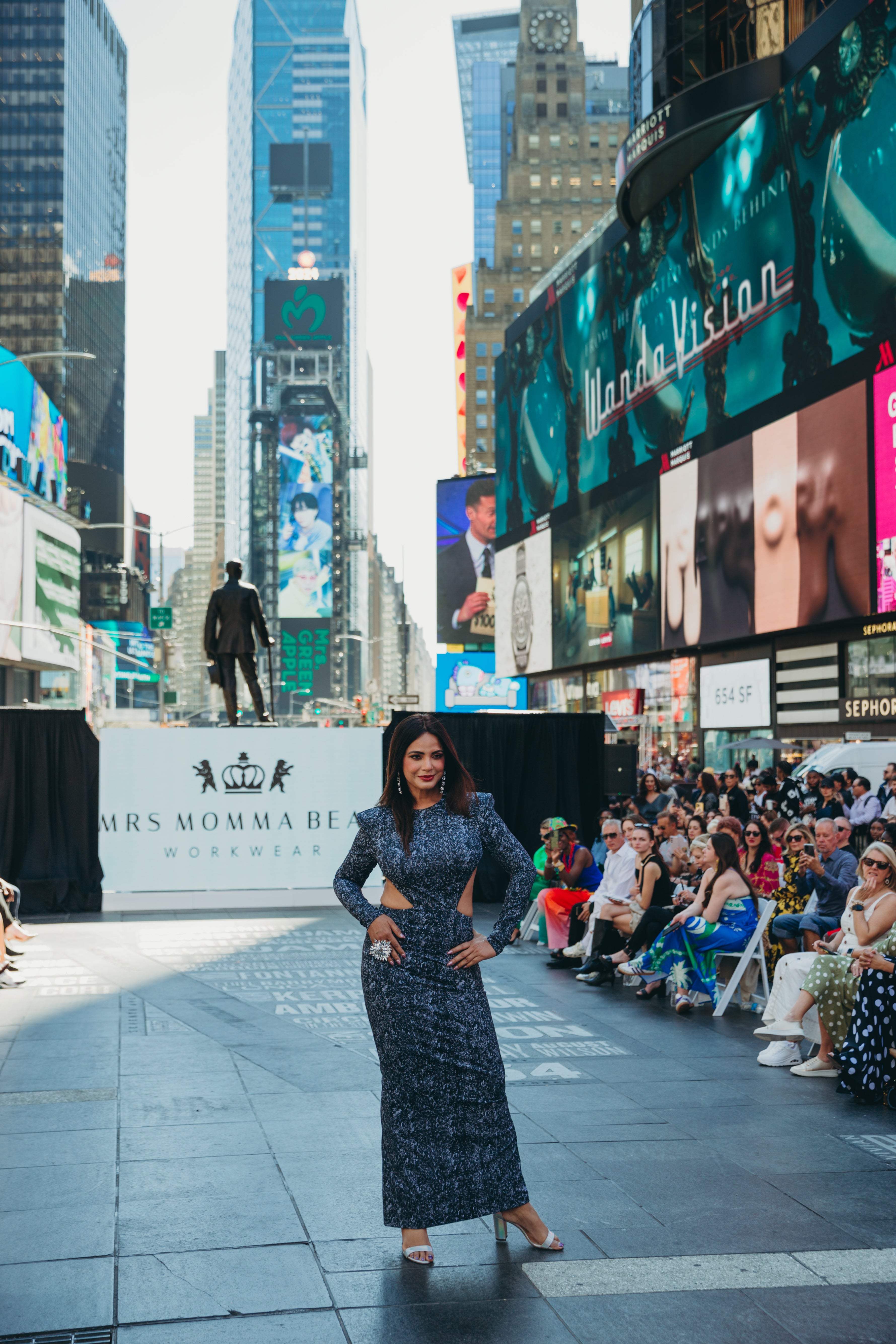 Model showcasing a Black Diamond on the runway at Times Square, surrounded by a vibrant audience and large digital screens.