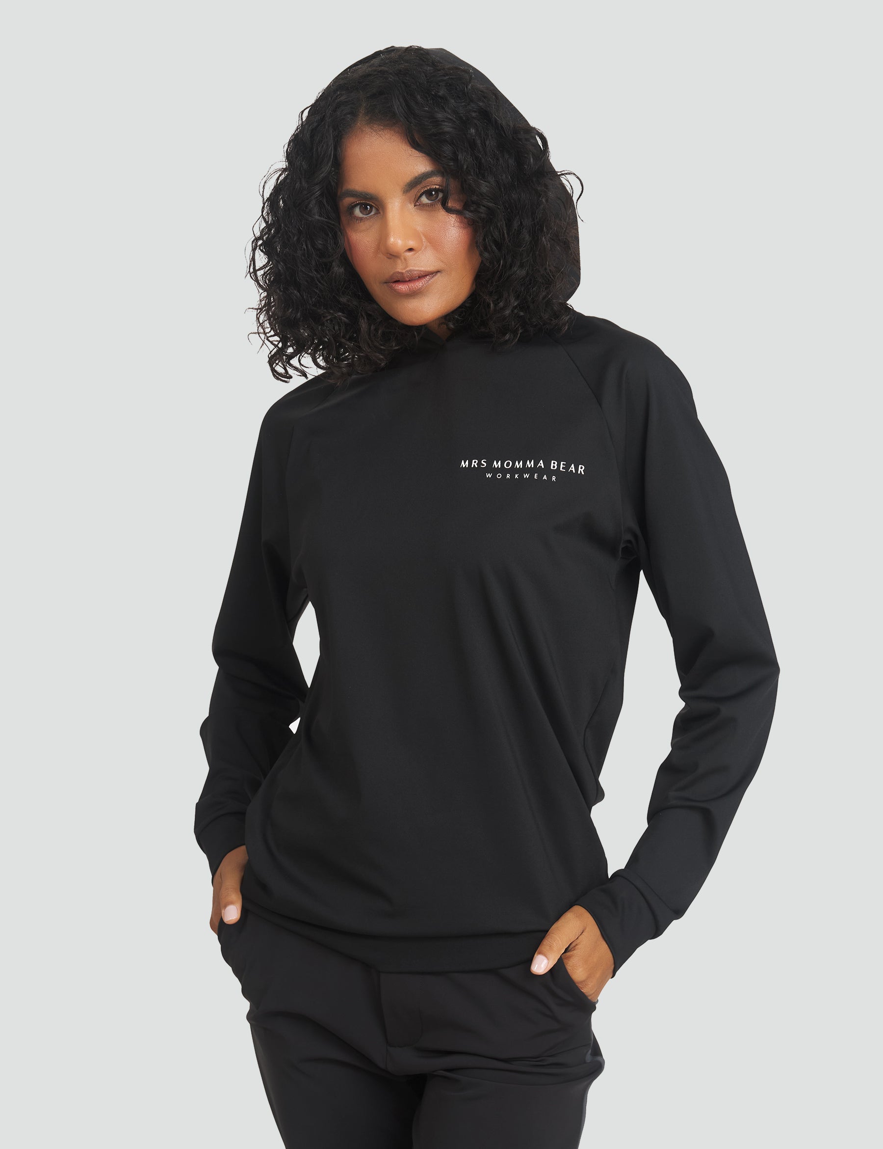 Woman wearing the Original MMB Hoodie, showcasing stylish unisex design in black, perfect for comfort and layering.