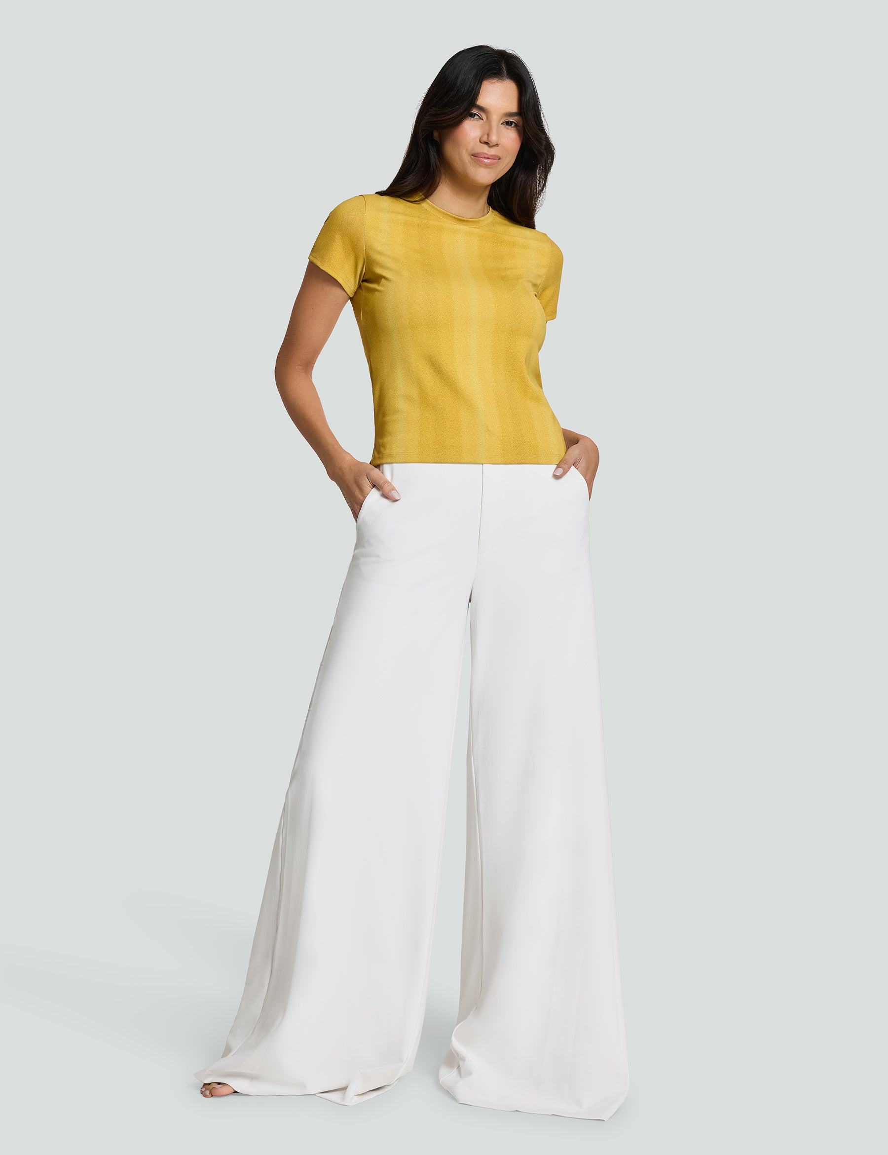 Woman wearing a yellow Signature Luxe Tee with white wide-leg pants, showcasing a casual yet stylish outfit.