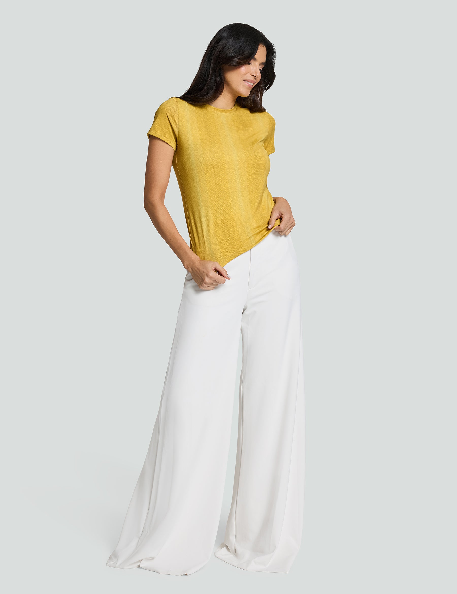 Model wearing a yellow Signature Luxe Tee paired with white wide-leg pants, showcasing a stylish casual look.