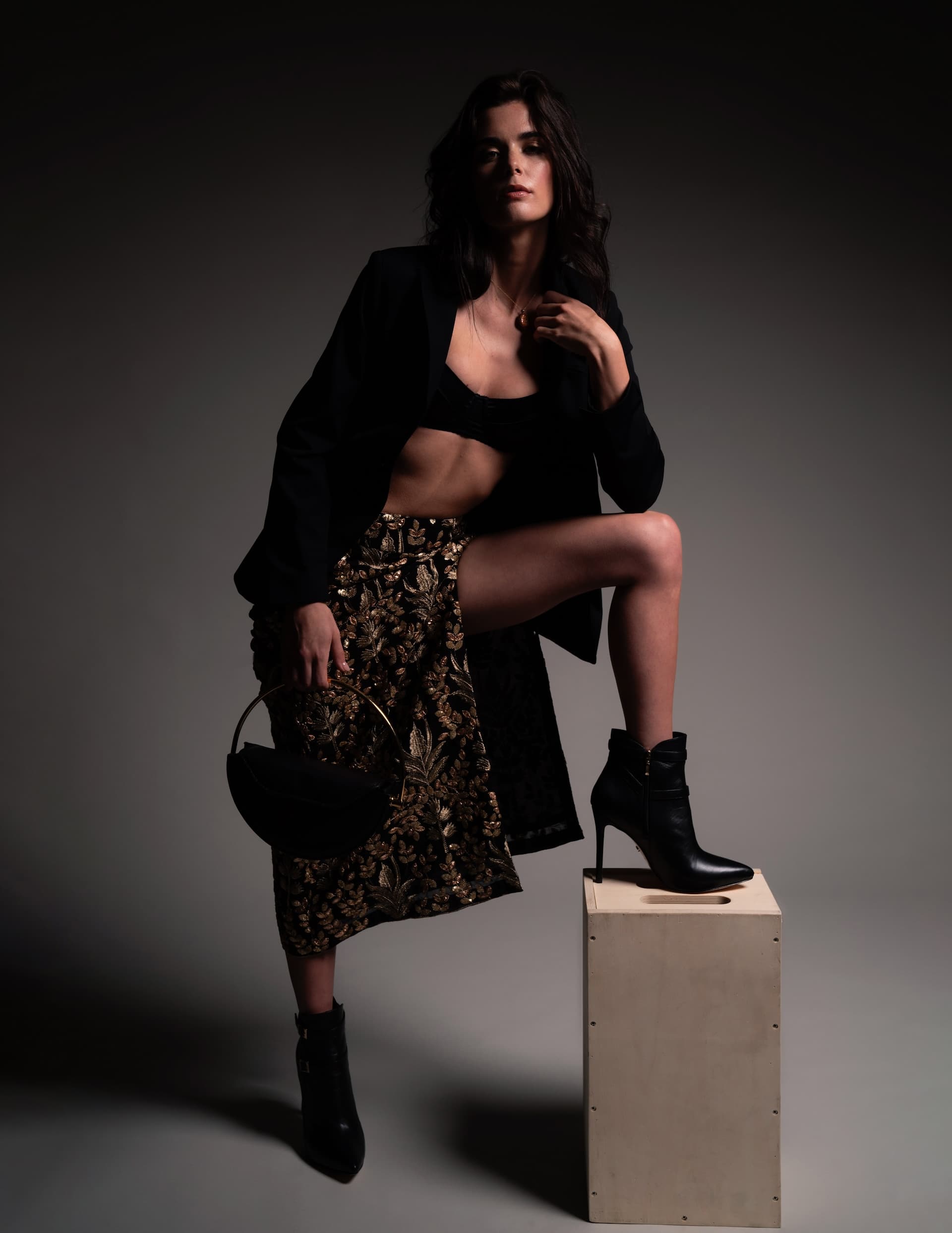 Model showcasing the You Hung the Moon blazer with a patterned skirt and ankle boots, posing confidently on a pedestal.