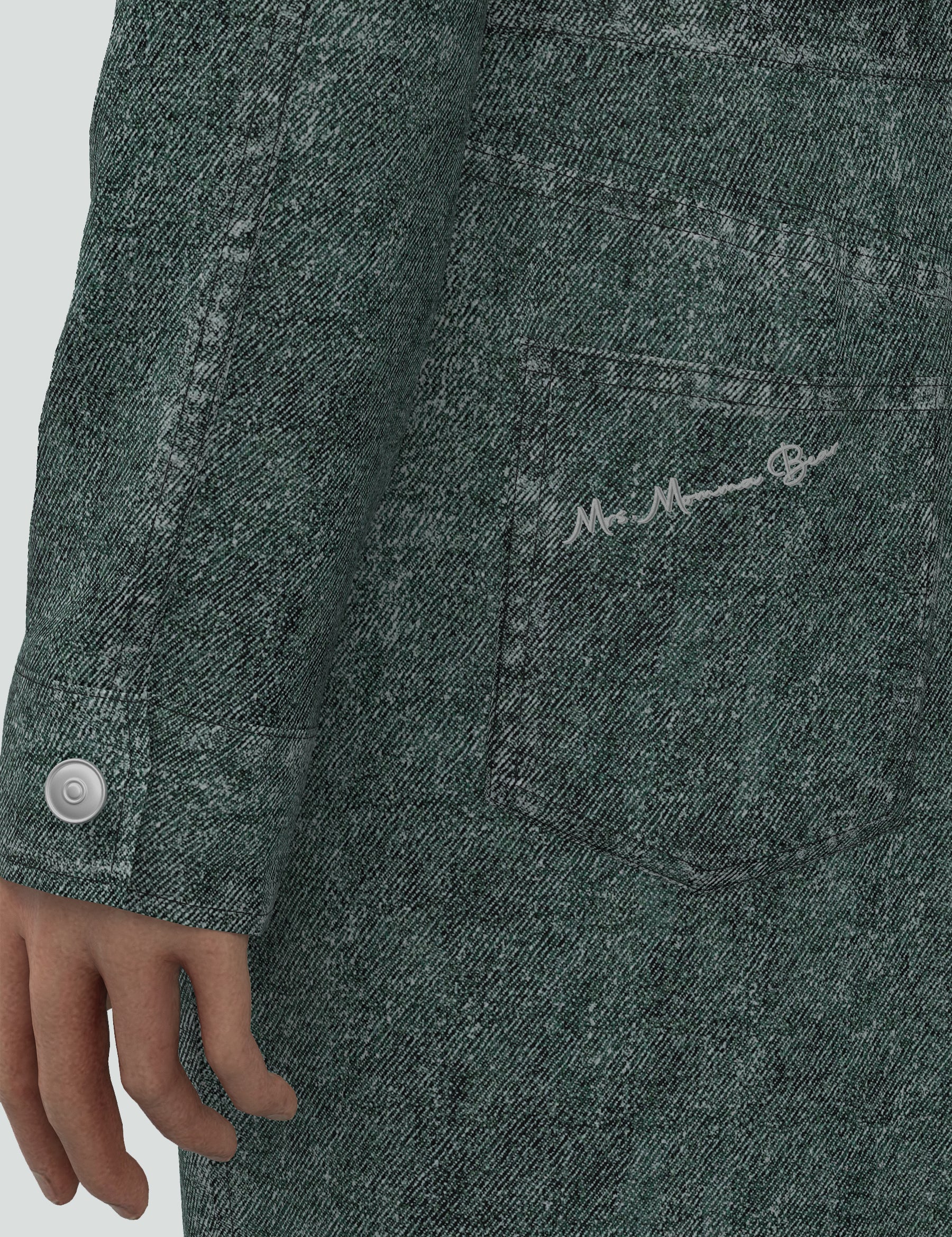 Close-up of the green denim mini dress showcasing the unique fabric texture and signature logo detail on the pocket.